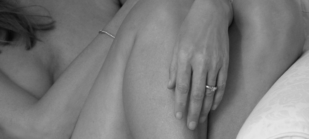 Photographie en noir et blanc de mains posées avec douceur, ambiance intimiste et poétique, célébration de la féminité, cliché artistique et sensible.